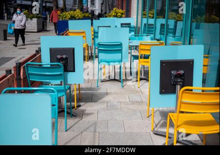 Watford, Großbritannien. April 2021. Stühle und Tische im Freien vor einem Restaurant in Watford High Street, Hertfordshire, da die Gegend ein wenig geschäftiger wird, da die Beschränkungen für die Sperrung durch Coronaviren langsam gelockert werden. Nicht unbedingt erforderliche Geschäfte werden am 12. April gemäß dem Fahrplan der britischen Regierung wieder eröffnet, der mehr Menschen dazu ermutigen wird, das Stadtzentrum zu besuchen. Kredit: Stephen Chung/Alamy Live Nachrichten Stockfoto