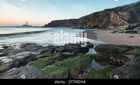 Blick von Old Hartley Bay, Northumberland, England, Großbritannien, mit Blick auf den St. Marys Leuchtturm, Whitley Bay und das offene Meer bei Sonnenaufgang. Stockfoto