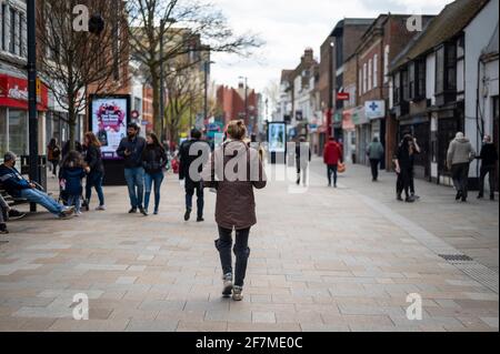 Watford, Großbritannien. April 2021. Menschen in Watford High Street, Hertfordshire, während die Gegend ein wenig geschäftiger wird, da die Beschränkungen für die Sperrung von Coronaviren langsam gelockert werden. Nicht unbedingt erforderliche Geschäfte werden am 12. April gemäß dem Fahrplan der britischen Regierung wieder eröffnet, der mehr Menschen dazu ermutigen wird, das Stadtzentrum zu besuchen. Kredit: Stephen Chung/Alamy Live Nachrichten Stockfoto