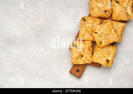 Blätterteig gefüllt mit Spinat, Huhn und Käse auf Holzbrett. Draufsicht Stockfoto