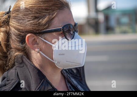 Lateinamerikanische Frau mit KN95-Maske, als sie in den Straßen der Stadt auf Essen geht. Es ist ein Tag nach dem Aufenthalt bei Home Order durch die Provinz Ontario Stockfoto