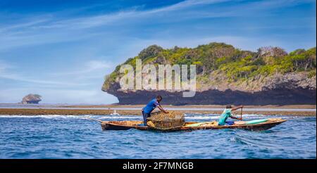 Wasini Island, Kenia, AFRIKA - 26. Februar 2020: Zwei Fischer mit einem großen Netz auf einem typischen Holzkanu im Indischen Ozean. Stockfoto