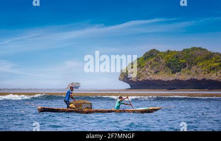 Wasini Island, Kenia, AFRIKA - 26. Februar 2020: Zwei Fischer mit einem großen Netz auf einem typischen Holzkanu im Indischen Ozean. Stockfoto