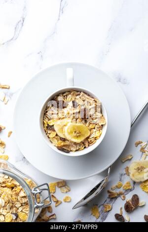 Schüssel Milch mit Vollkornprodukten zum Frühstück. Müsli mit getrockneten Früchten und getrockneten Früchten. Mit Kopierbereich. Auf hellem Hintergrund. Stockfoto
