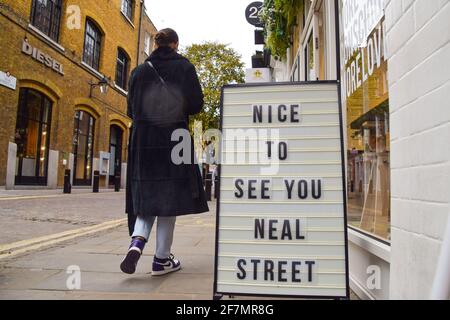 London, Großbritannien. April 2021. Eine Frau kommt an einem Schild vorbei, auf dem steht: "Nice to See You Neal Street" in der beliebten Einkaufsstraße in Covent Garden, bevor die Sperrungsbeschränkungen weiter aufgehoben werden.Geschäfte, Restaurants und andere Unternehmen werden am 12. April wiedereröffnet. Kredit: SOPA Images Limited/Alamy Live Nachrichten Stockfoto