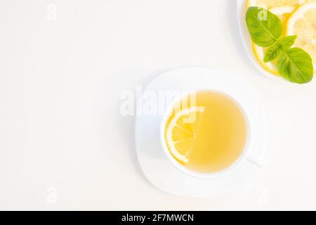 Tasse grüner Tee mit Zitrone, Basilikum und Minze schießen von oben isoliert auf weißem Hintergrund mit Platz für Text Stockfoto