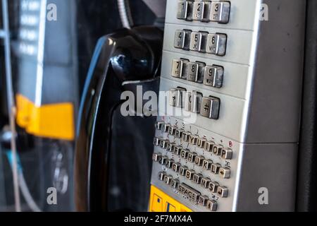Ein altes verprügeltes Telefon in einem Einkaufszentrum im Südwesten von Ontario, Kanada. Schwarzer Empfänger, gelber Softfokus-Steckplatz für Kreditkarten. Silbernes Tastenfeld. Stockfoto