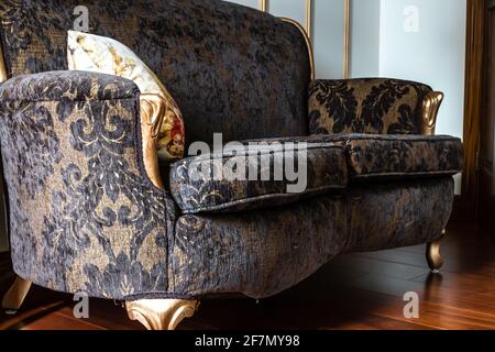 Angewinkeltes Foto eines französischen Loungesitzes im Renaissance-Stil mit schwarzem Spitzenmuster und goldenen Beinen in Ontario, Kanada, Februar 2021. Stockfoto