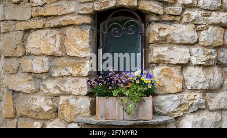 Kleines Fenster in der Steinmauer Stockfoto