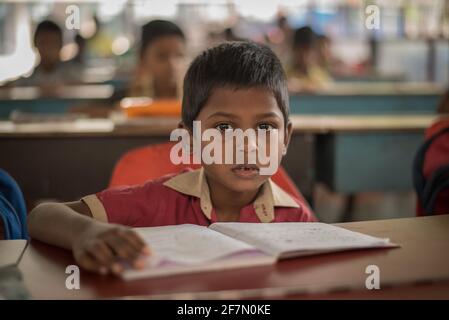 Varanasi, Indien. 10-14-2019. Porträt eines Jungen, der während des Unterrichts in der Schule auf seiner Bank sitzt. Stockfoto