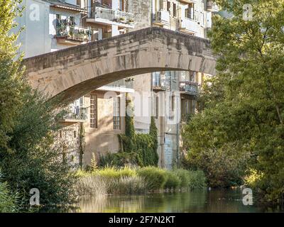 Die mittelalterliche Brücke Puente Carcel mit Häusern im Hintergrund, Estella, Spanien, 17. Oktober 2009 Stockfoto