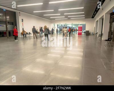 Bologna, Italien - 2021. April: Menschen mit chirurgischen Masken stehen in der Schlange im italienischen Impfzentrum, um sich mit dem Impfstoff AstraZeneca impfen zu lassen Stockfoto