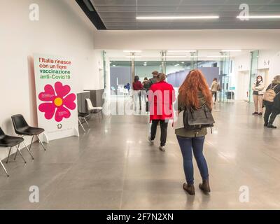 Bologna, Italien - April 2021: Menschen mit chirurgischen Masken stehen in der Schlange im italienischen Impfzentrum, um sich mit dem neuen Impfstoff impfen zu lassen Stockfoto