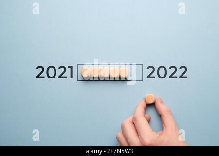 Konzept für den Übergang des Jahres von 2021 auf 2022 auf Holzwürfeln mit Ladebar. Stockfoto