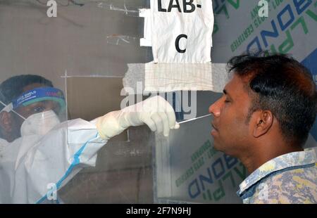 Guwahati, Indien. April 2021. Am 8. April 2021 holt ein Mitarbeiter des Gesundheitswesens einen Tupfer von einem Passagier am Bahnhof Guwahati in Assam, Indien, ab. In den letzten 24 Stunden wurden in Indien bis zu 126,789 neue COVID-19-Fälle registriert, so die offiziellen Daten des Bundesgesundheitsministeriums vom Donnerstag. Quelle: Str/Xinhua/Alamy Live News Stockfoto