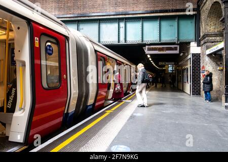 Passagiere steigen an der Londoner U-Bahnstation Notting Hill Gate in einen Zug ein. Stockfoto