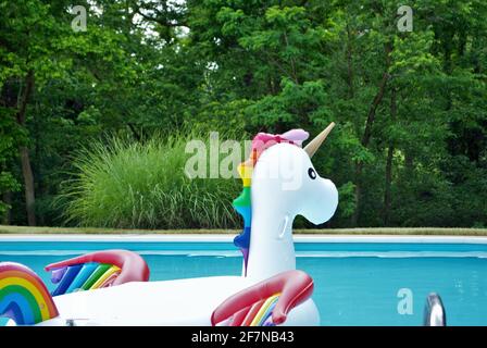 einhorn aufblasbar schwimmend in einem Hinterhof Schwimmbad Stockfoto