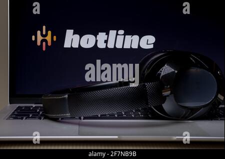 Logo der Hotline-App auf dem Smartphone mit Kopfhörern. Die Hotline-Plattform ist ein neuer Eintrag im Audio-Chat, der von Facebook, dem Konkurrenten des beliebten Clu, entwickelt wurde Stockfoto