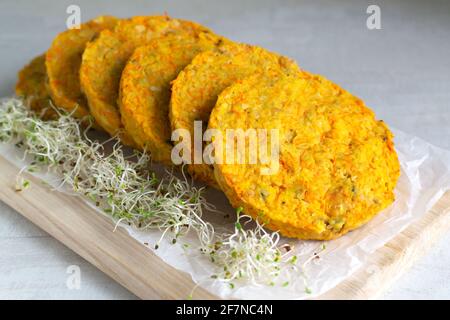 Kichererbsen-Schnitzel mit Mikroregrün im Ofen gebacken. Enthält Karotten, Zwiebeln, Knoblauch. Vegetarisches Speisekonzept. Horizontale Ausrichtung. Stockfoto