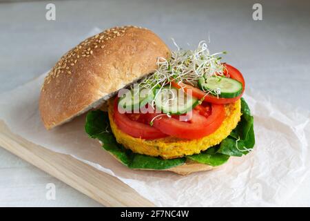 Veggie-Burger mit Kichererbsenschnitzel mit Tomaten, Gurken, Spinat und Microgreen. Vegetarisches Speisekonzept. Horizontale Ausrichtung. Stockfoto