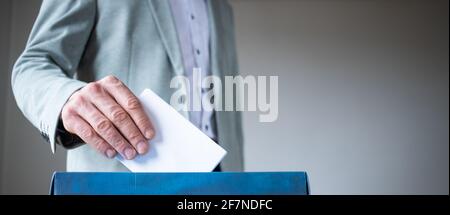 Männliche Hand, die die Stimme in die Abstimmung einbringt Stockfoto