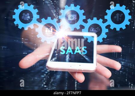 Business, Technologie, Internet und Netzwerkkonzept. Junger Geschäftsmann arbeitet auf einem virtuellen Bildschirm der Zukunft und sieht die Inschrift: SAAS Stockfoto