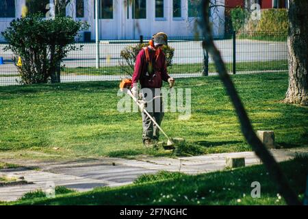 Reims Frankreich 08. April 2021 Gärtner mit einem Hand-Rasenmäher im Frühjahr in einem öffentlichen Park in der Stadt Reims in Frankreich Stockfoto