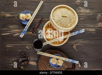 Shumai Shaomai Chinesisches Fleischknödel gedünstetes Gericht in Bambus-Dampfgarer-Box. Essstäbchen und Dimmen. Stockfoto