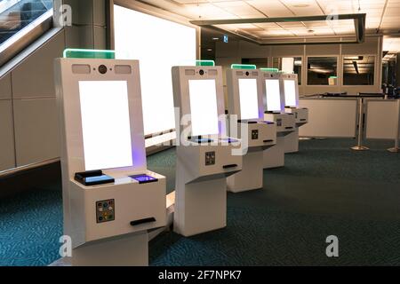 Reihe mit Selbstbedienungskartenspender mit Passscanner Touch Bildschirm in der Einwanderungszone am Flughafen Stockfoto