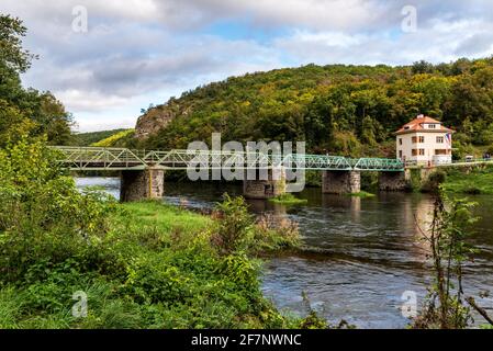 Thaya Fluss mit Grenzbrücke oben, Gebäude mit tschechischer Flagge und bewaldeten Hügel in der Nähe von Hardegg Stadt an österreichisch-tschechischen Grenzen in Thayt Stockfoto