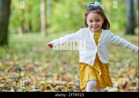 Happy Running hübsches Mädchen auf verschwommenem Herbst Park Hintergrund Stockfoto