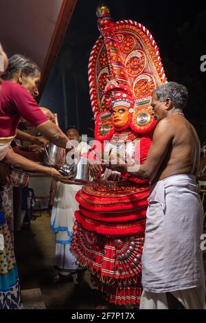 Payyanur, Indien - 5. Dezember 2019: Theyyam-Künstler treten während des Tempelfestivals in Payyanur, Kerala, Indien, mit Feuer auf. Theyyam ist ein beliebtes Ritual für Stockfoto