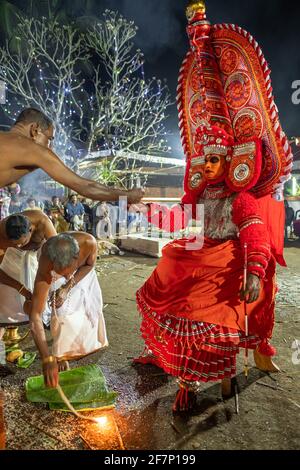 Payyanur, Indien - 5. Dezember 2019: Theyyam-Künstler treten während des Tempelfestivals in Payyanur, Kerala, Indien, mit Feuer auf. Theyyam ist ein beliebtes Ritual für Stockfoto