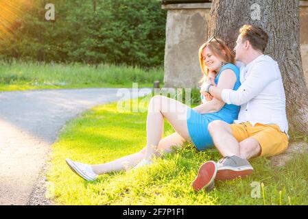 Glücklich und verliebt. Junges Paar Umarmt Unter Baum. Liebespaar unter Baum liegend und küssend Stockfoto