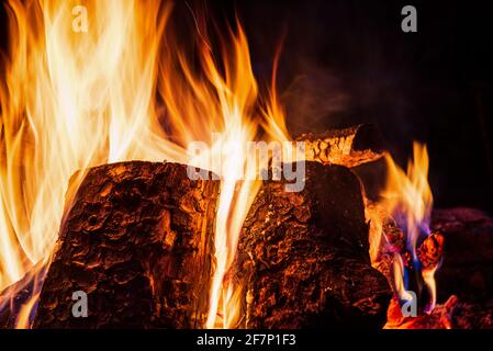 Nachtlager mit verfügbarem Platz. Großes Lagerfeuer vor schwarzem Hintergrund. Funken von Lagerfeuer und Feuer aus der Nähe Stockfoto