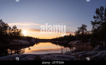 Panoramablick auf den Sonnenuntergang im schwedischen Archipel. Felsen, ruhiges Wasser und Küstenfeatures an diesem ruhigen Abend. Foto aufgenommen in Oskarshamn, Schweden Stockfoto