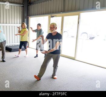 Gruppe von Senioren in Tai Chi Klasse Ausübung in einem aktiven Ruhestand Lebensstil. Psychische und körperliche Gesundheit Vorteile von Bewegung und Fitness bei älteren Menschen Stockfoto