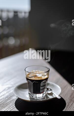Morgens gab es ein Glas heißen, dampfenden schwarzen Kaffee auf dem Tisch Stockfoto
