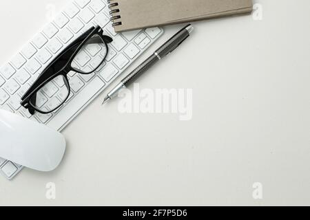 Brille Pen Maus Tastatur und Notizblock auf weißem Hintergrund. Nahaufnahme Stockfoto