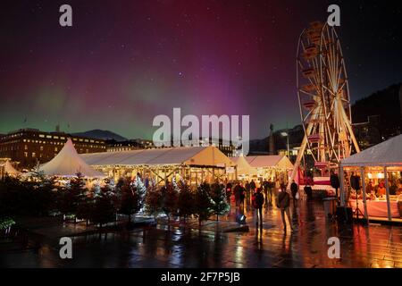 Aurora über Bergen Weihnachtsmarkt, Bergen, Norwegen. (Zusammengesetztes Bild) Stockfoto