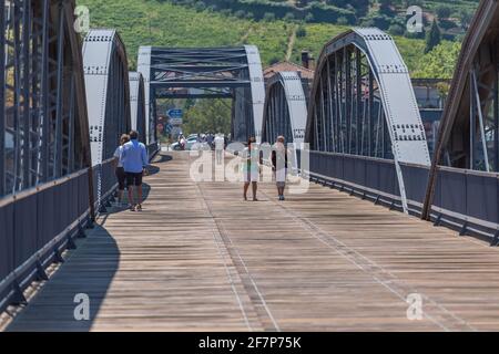 Regua / Portugal - 10/02/2020 : Blick auf ein touristisches Volk auf dem Rücken, der durch die metallische Brücke der Stadt Peso da Regua schlendert Stockfoto