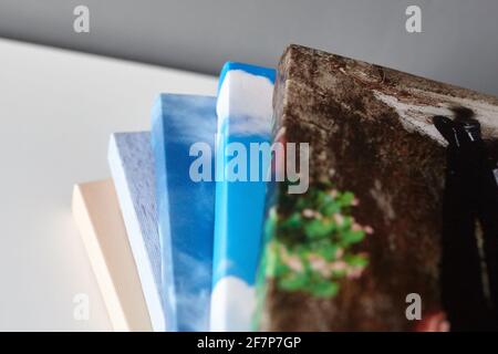 Leinwanddrucke auf weißer Oberfläche auf grauem Wandhintergrund gestapelt. Foto auf Leinwand gedruckt. Gestreckte Fotos mit Gallery Wrapping Stockfoto