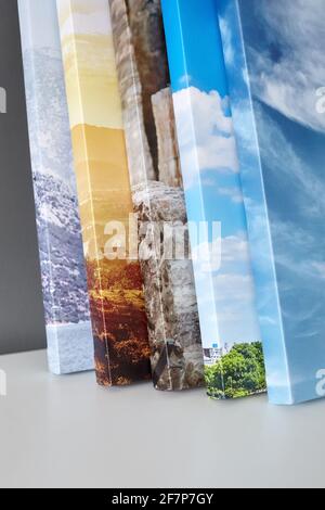 Leinwanddrucke auf weißer Oberfläche auf grauem Wandhintergrund gestapelt. Foto auf Leinwand gedruckt. Gestreckte Fotos mit Gallery Wrapping Stockfoto