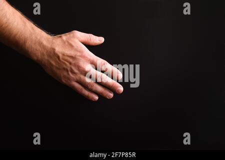 Die Hand eines Mannes auf schwarzem Hintergrund. Stockfoto