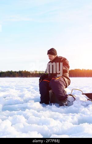 Eisfischen. Fischer fischen auf gefrorenem See. Winter frostigen Morgen Angeln auf dem Fluss. Stockfoto