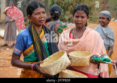 Laxmipur, Indien - 2021. Februar: Adivasi-Frauen vom Stamm Kondh kaufen am 20. Februar 2021 auf dem Laxmipur-Markt in Odisha, Indien, Rohrkörbe. Stockfoto