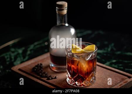 Ein wunderschöner altmodischer Cocktail, serviert mit einem mit Kaffee angereichertem Rum über Eis auf einem Steinglas. Der Cocktail wird in einer Flasche mit Rauch präsentiert Stockfoto