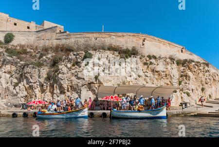 Malta, Wied iz-Zurrieq: Bunt bemalte alte Fischerboote machen einen Ausflug zur Blauen Grotte. Stockfoto