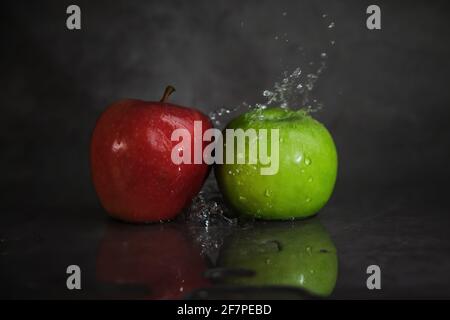 Rote und grüne Äpfel in Wasserspritzern Stockfoto