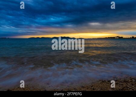 Starke Wolken und starker Wind mit Wellen am Abend an der Adriaküste in Istra während Sonnenuntergang, Kroatien Stockfoto